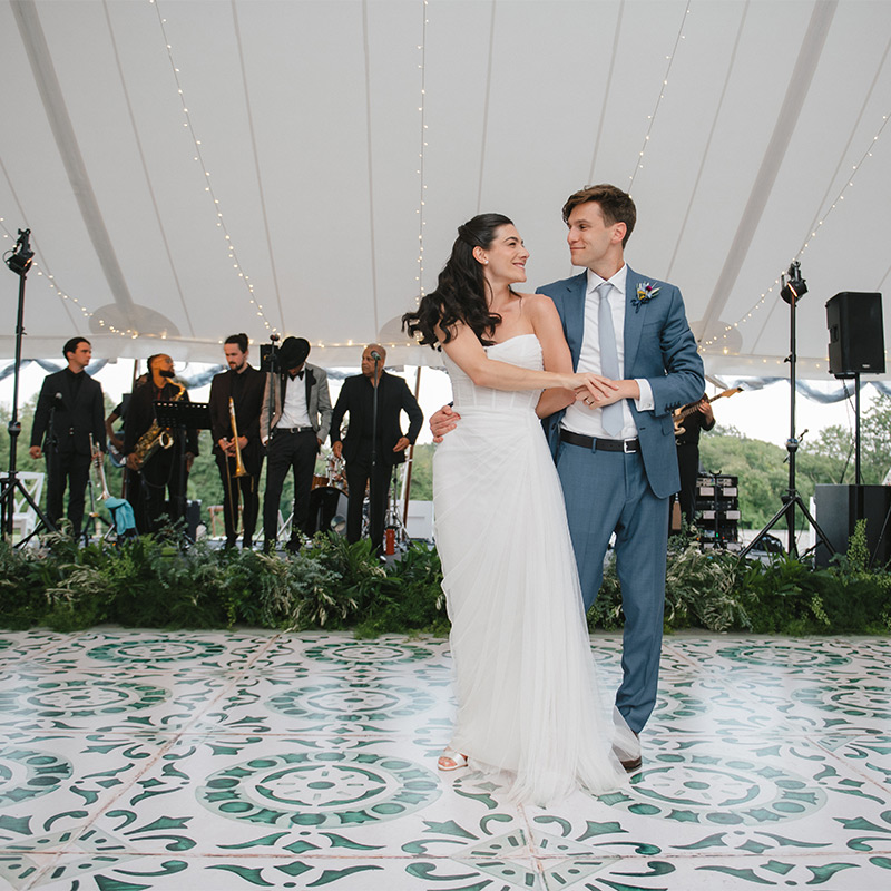 A very happy and modern looking bride and groom dance upon a vinyl dance floor wrap that has been printed to look like classic Portuguese floor tiles. Just beautiful!