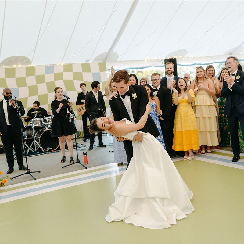 At this wedding, the vinyl dance floor wrap was printed in the same colors as the custom-printed backdrop that framed the wedding band.