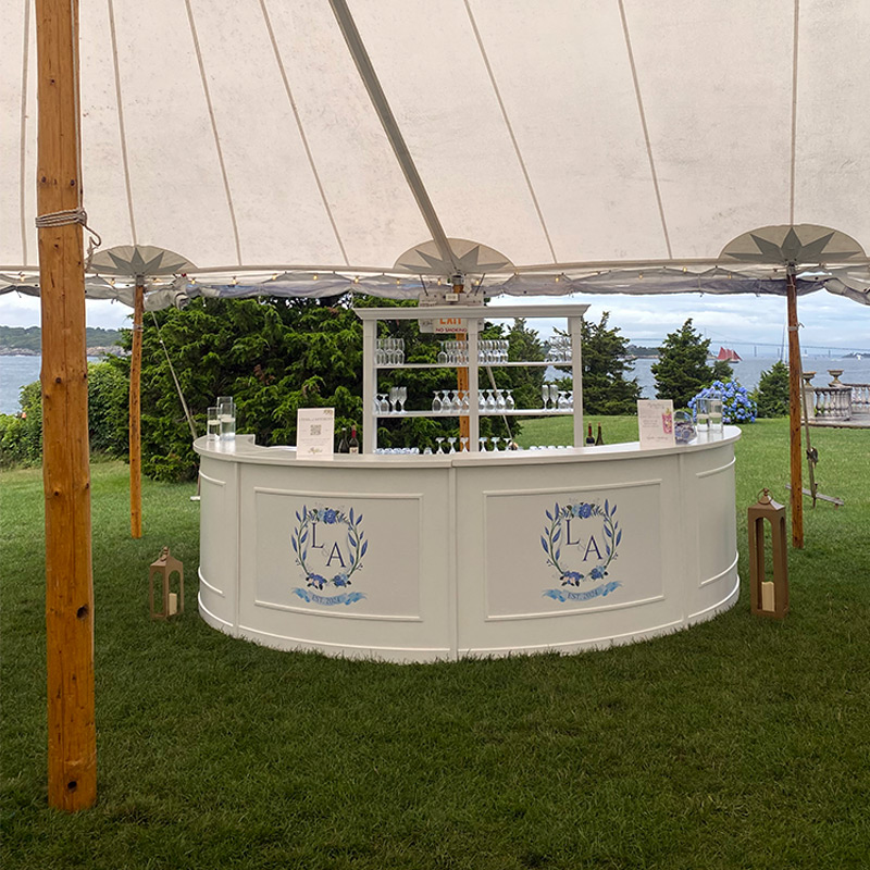 Contour cut decals featuring the bride and groom's initials as a monogram have been used to create custom decoration for one of the service bars at this outdoor wedding venue.