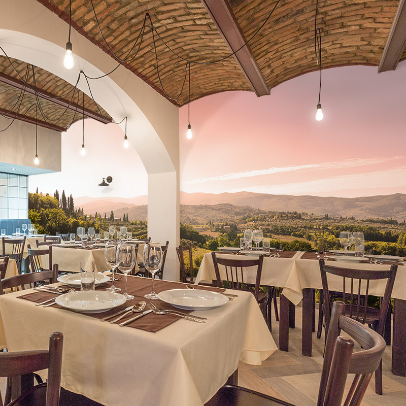 Fine dining restaurants and upscale eateries can be well-served with a wallpaper mural as this Tuscany, Italy photographic mural demonstrates in this award-winning Italian trattoria. The view of the Italian Alps makes this small venue look immense.