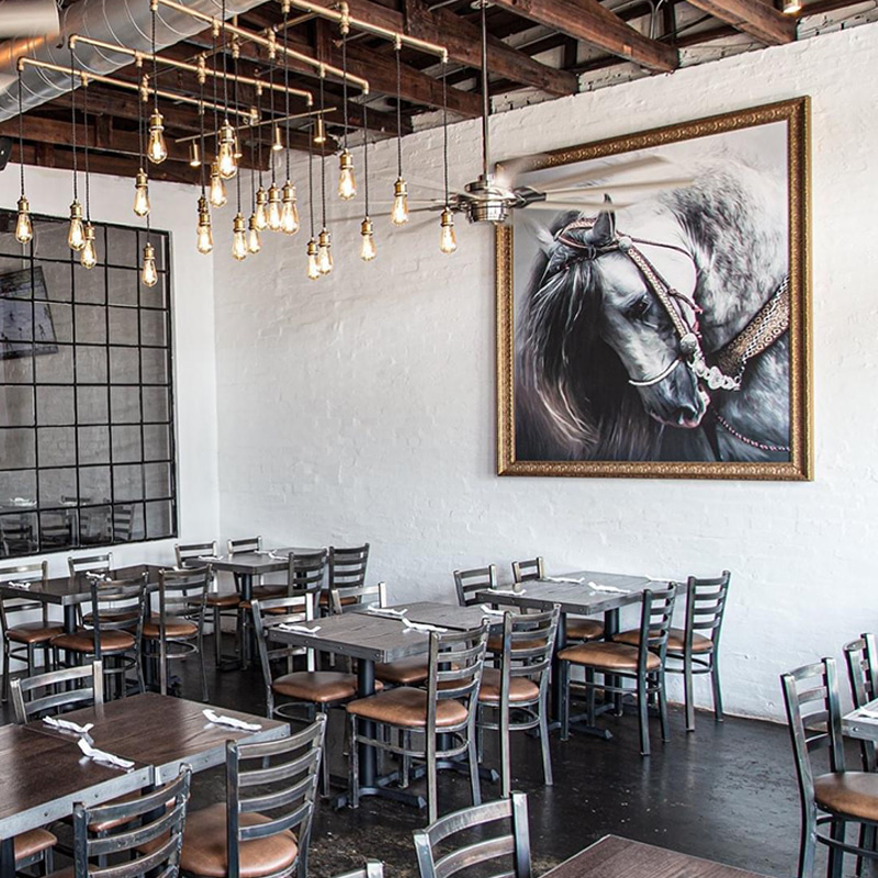 Barrocos Latin Cuisine in Rowlett, TX achieved a decidedly upscale look by decorating the focal wall in its dining room with a framed wallpaper mural featuring a Spanish stallion. Small murals can have a huge impact in a dining room.