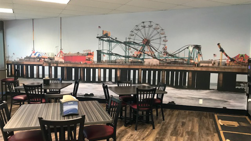 A 30 foot long wallpaper mural featuring the Atlantic City Pier decorates the corporate cafeteria in a high tech center in Edison, New Jersey. A great example of how restaurant décor can connect with customers by featuring local landmarks and attractions.