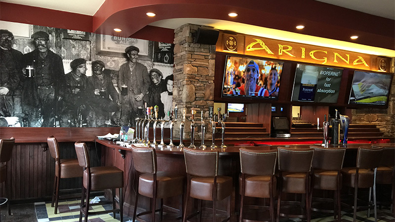 A custom printed wallpaper mural featuring a vintage photograph of coal miners from the restaurant owner's private collection of memorabilia graces the bar of the Arigna Irish Pub in Pawtucket, Rhode Island.