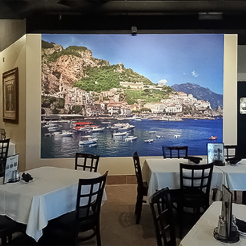 In this photo, we see a wallpaper mural featuring the Mediterranean cliff side village of Cinque Terre, Italy gracing the dining room of Marco's Italian Bistro in Scottsdale, Arizona. What better way to ensure your diners truly appreciate your cuisine?