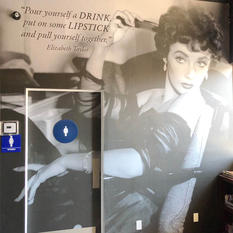 Restaurant patrons hate having to ask the waitstaff where the restrooms are. With this 12 foot high mural of Elizabeth Taylor pointing the way, not only has this venue removed the embarrassment of having to ask, they've made it a fun journey.