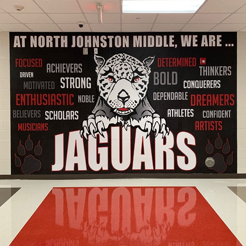 The Jaguar school mascot on this large mural at Johnston Middle School acts as a focal point in the school&rsquo;s lobby, welcoming students, teachers, parents and the community. Word art provides inspiration and motivation.