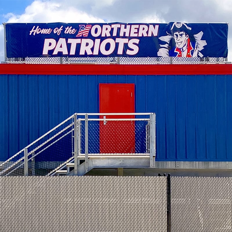 Stadium banners are a great way to bring school spirit to football arenas and basketball stadiums. Here, a vinyl printed banner featuring Northern High School’s patriot mascot adorns the top of the announcer’s booth at the school’s football stadium.