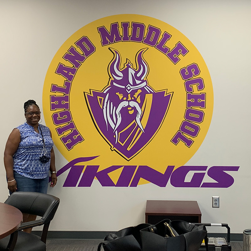 This contour cut wall decal features the Highland Middle School mascot and team name in school colors. The decal is circular die-cut around the entire graphic as a whole for easy installation.