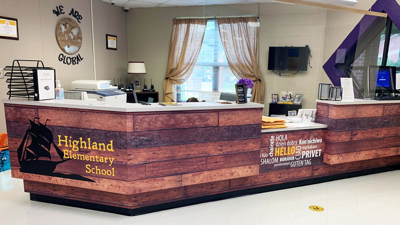 This reception desk in the main administration & principal’s office at Highland Elementary School in Sanford, NC just hints at their Pirates mascot and team name by invoking the wooden side of an old pirate ship.