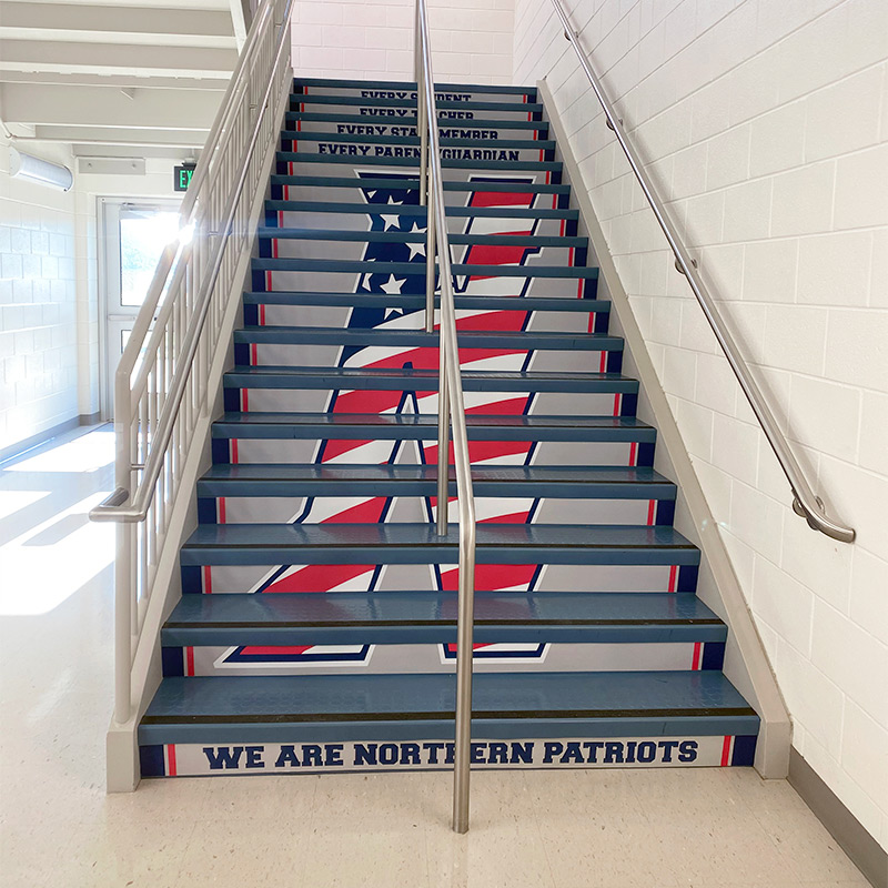 Northern High School in Owings, MD celebrates their championship football team in this stairwell, where decals on the stair risers form together to create their school logo. Stickers on other stair risers use word art to provide inspirational messaging.