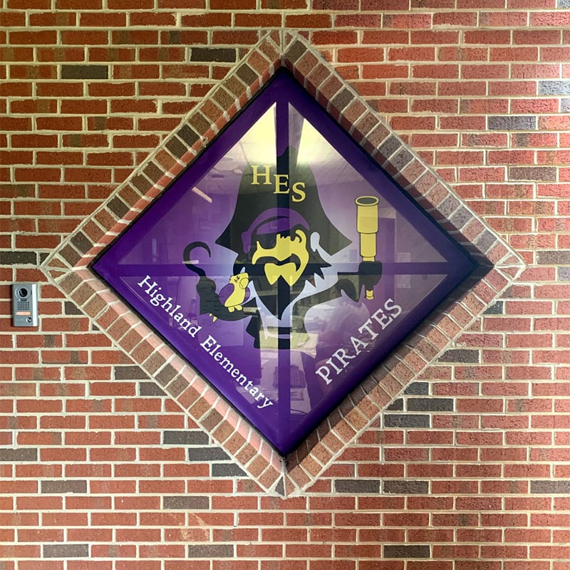A perforated window film (aka “window perf”) printed with the mascot of Highland Elementary School in the school’s colors provides privacy to the staff inside the office while greeting visitors at the entrance.