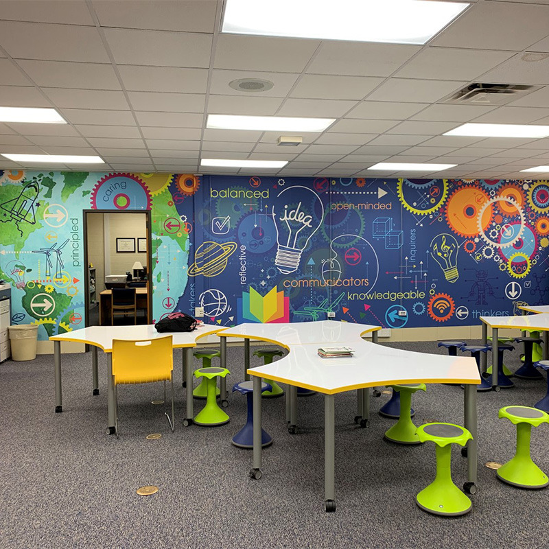 The wall mural in this school library media center inspires and motivates students with word art and vibrant graphics. Murals like this are perfect for classrooms too.