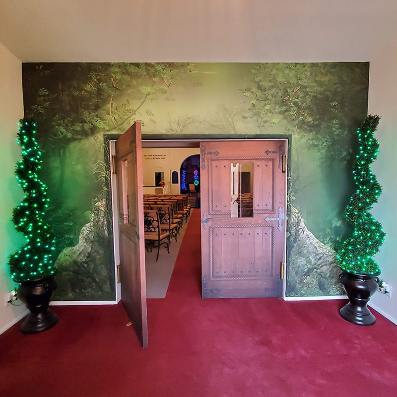 A mystical forest mural and some modern lighting adorn the foyer of this local church.