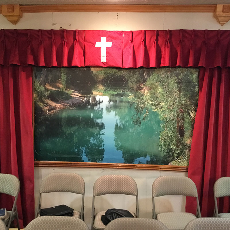 A wallpaper mural featuring the River Jordan graces the baptistry of this more traditional and conservative Baptist church.