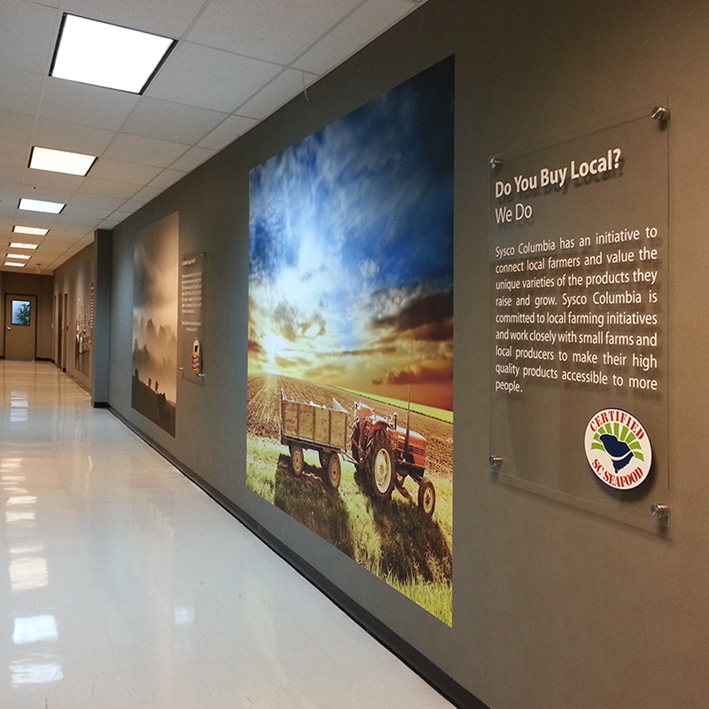 A corporate hallway adorned with wall murals featuring photos of the company's connection to farms and nature.