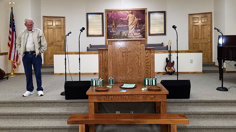The main stage and worship area of the Liberality Baptist Church in Madisonville, TN is adorned with a framed wall mural wallpaper of a vintage Christian artwork called "The Baptism"