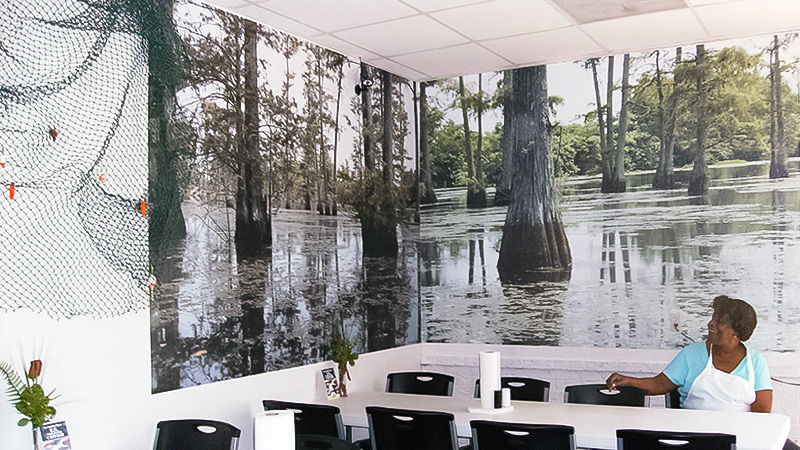 A nature mural in a corporate lunch room and cafeteria features a swamp in the Louisiana bayou.